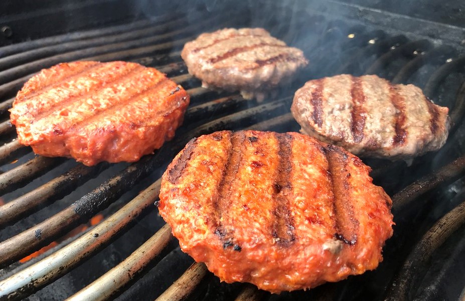 Plant-based meat patties on a grill