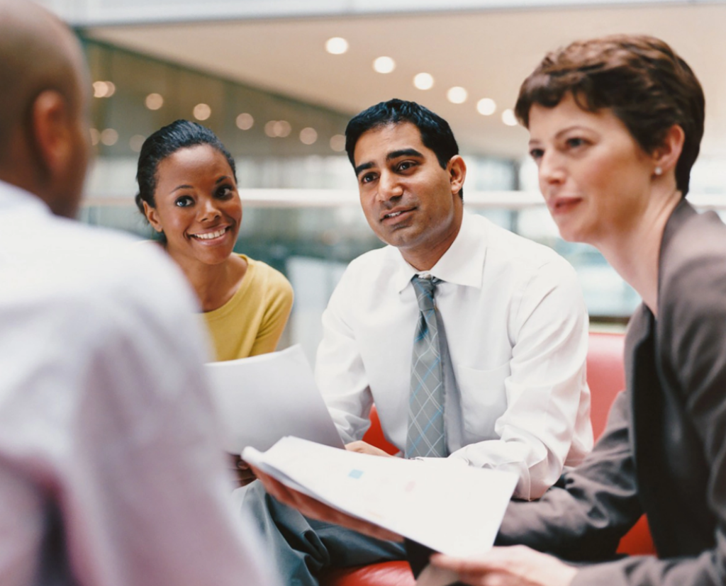 Four diverse people in professional attire having a meeting