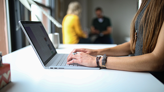 person using macbook pro on table